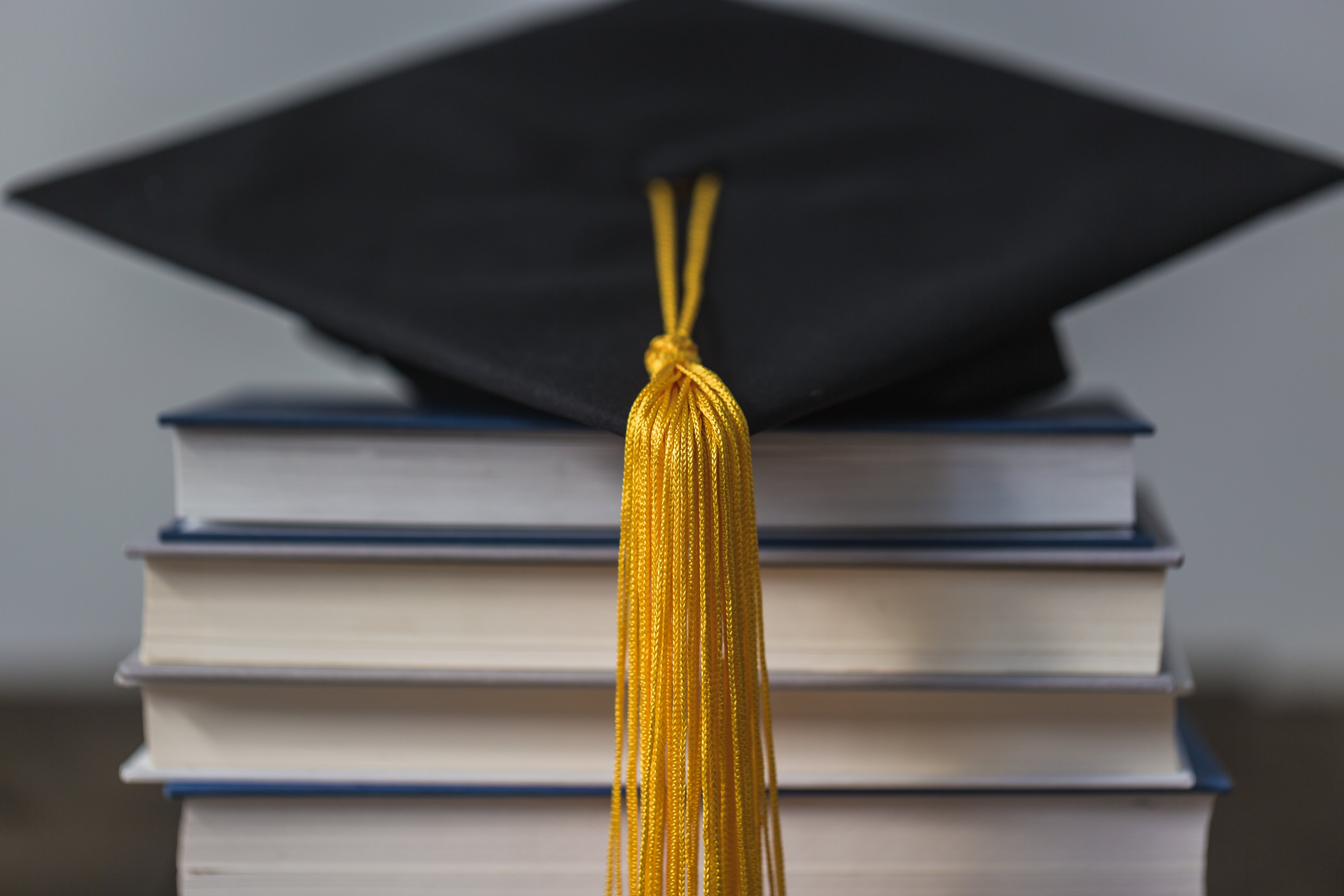 graduation-cap-gold-tassle-and-books.jpg